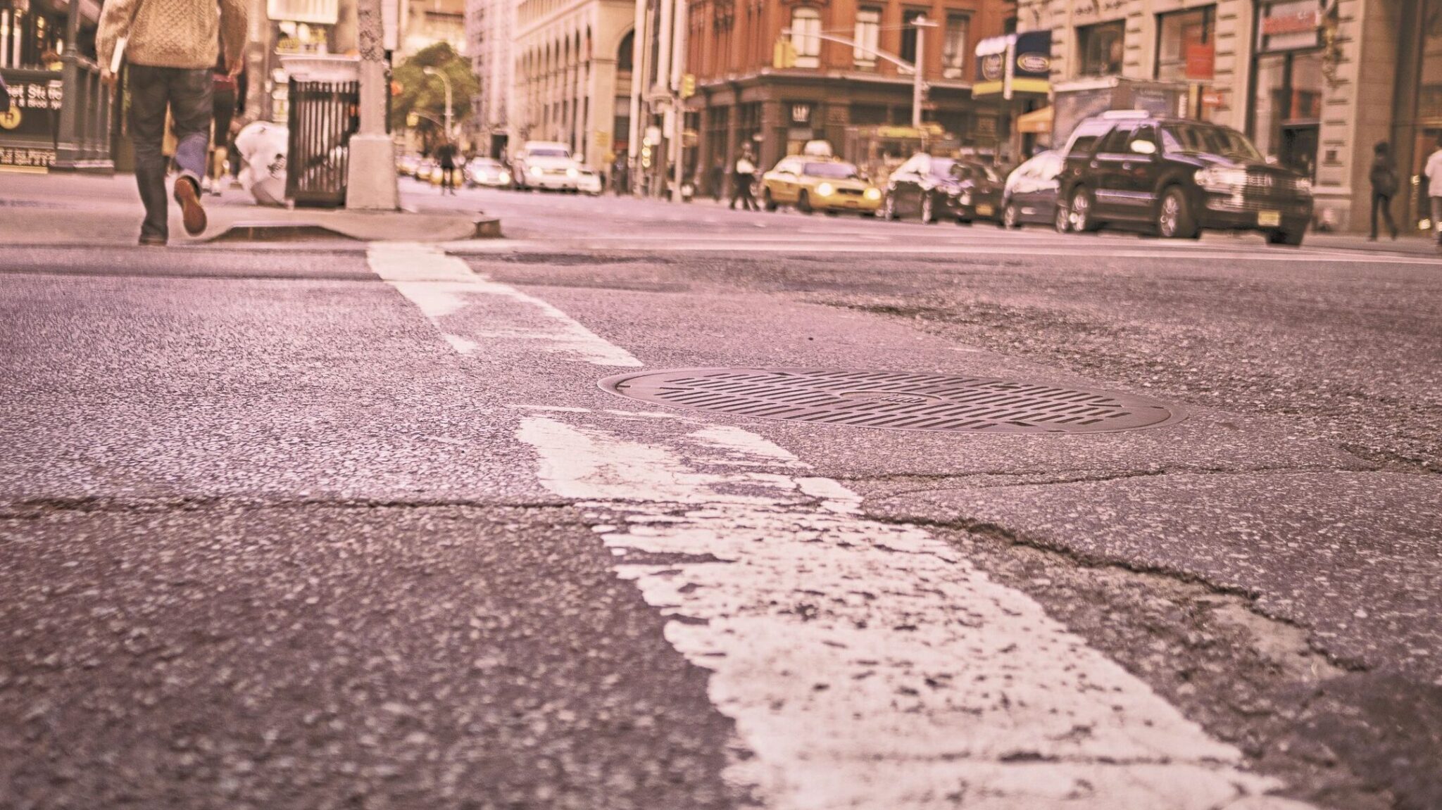 A guy crosses the street downtown.