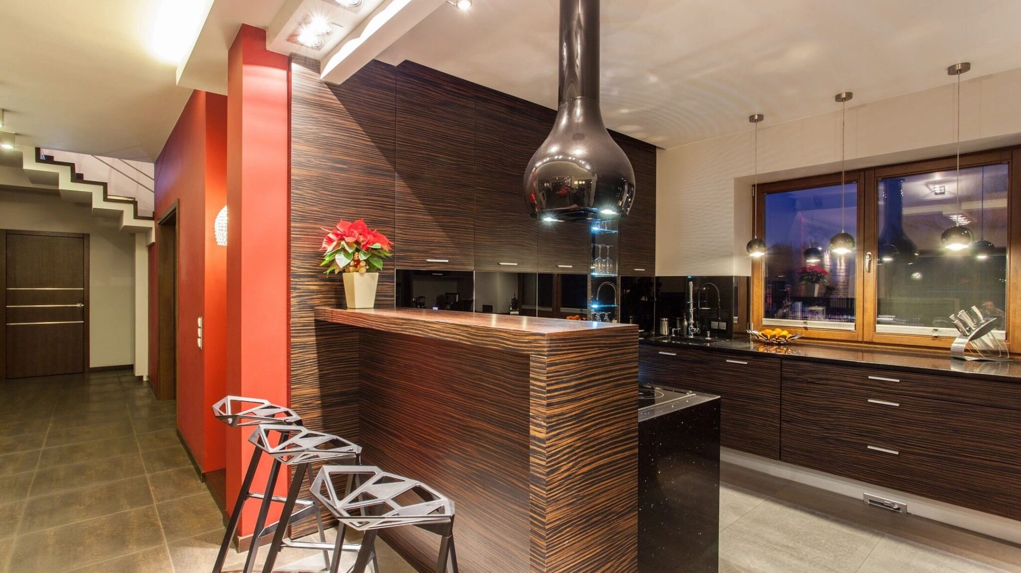 A sleek kitchen island in zebra print brown and black countertops with red and white walls.