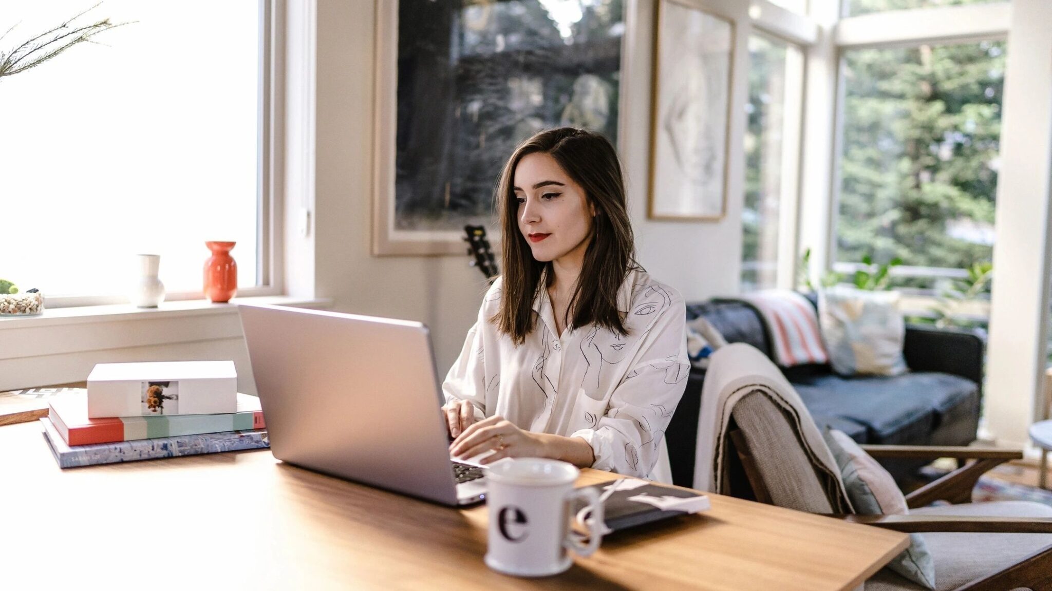 An investor sits at her dining room table on her laptop researching real estate emerging markets.