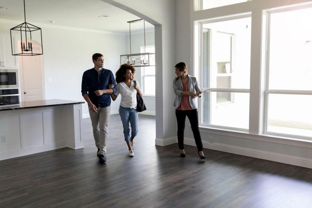 First-time home buyers touring a property with a real estate agent